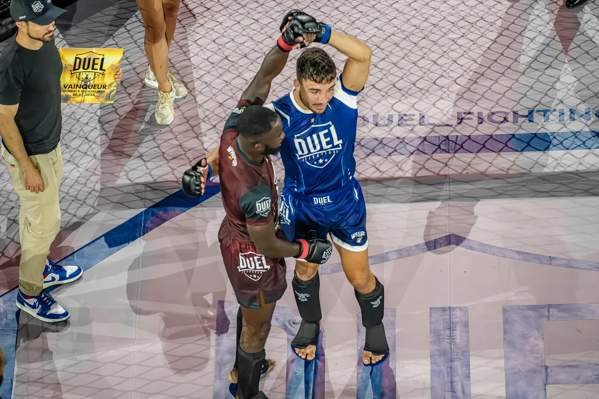 Le vainqueur lève le bras de son adversaire après le combat