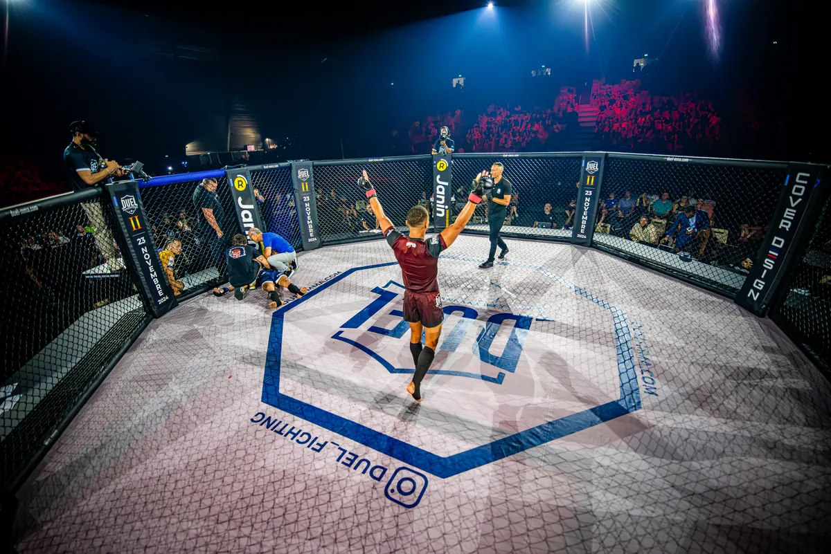 Un combattant DUEL célèbre sa victoire dans la cage